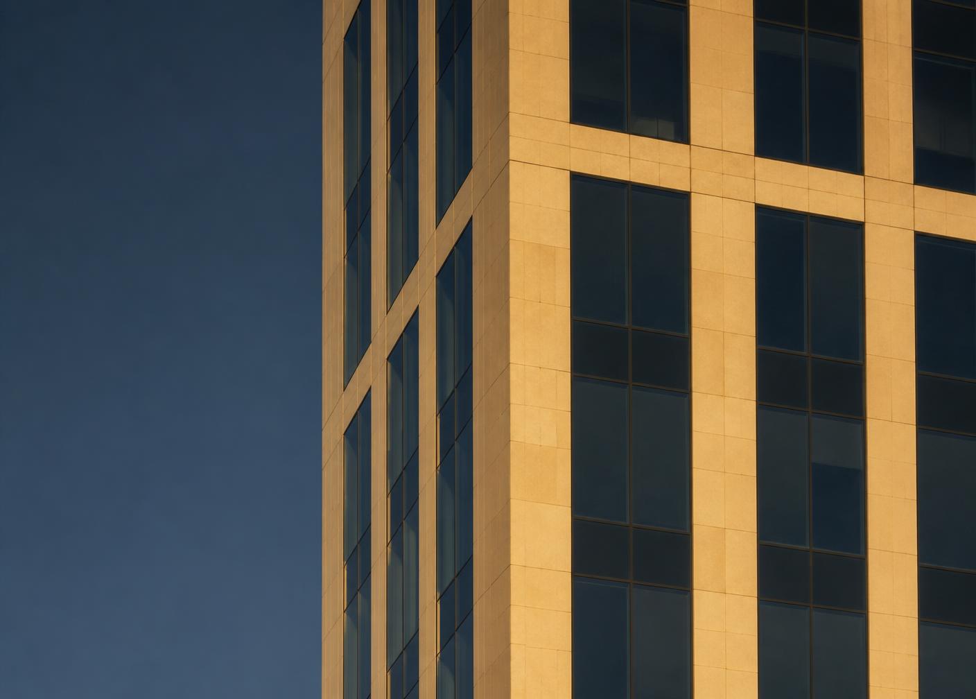 Limestone and glass office tower along the Wilshire corridor at last light